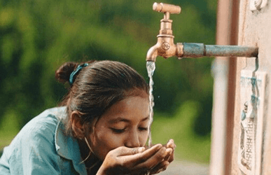 Ребёнок пьёт чистую воду из крана